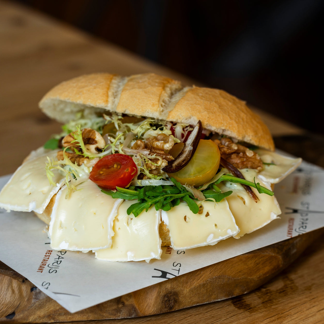 Vegetarisch broodje brie met roombrie, walnoot en zoetzure tomaatjes van Stad Parijs Bezorgservice